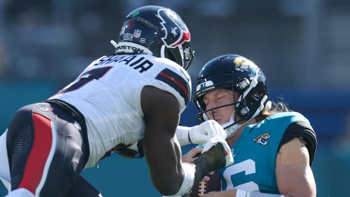 Dec 1, 2024; Jacksonville, Florida, USA; Jacksonville Jaguars quarterback Trevor Lawrence (16) slides down in front of Houston Texans linebacker Azeez Al-Shaair (0) in the second quarter in the second quarter at EverBank Stadium. Mandatory Credit: Nathan Ray Seebeck-Imagn Images