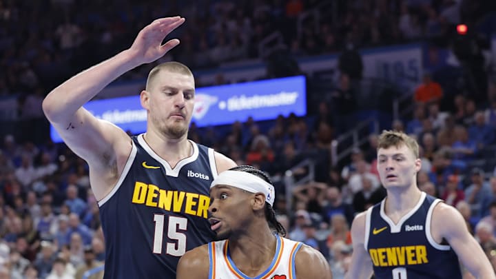 Mar 10, 2025; Oklahoma City, Oklahoma, USA; Denver Nuggets center Nikola Jokic (15) defends a drive by Oklahoma City Thunder guard Shai Gilgeous-Alexander (2) during the second half at Paycom Center. Mandatory Credit: Alonzo Adams-Imagn Images