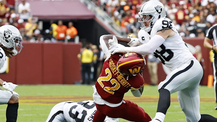 Sep 21, 2025; Landover, Maryland, USA; Washington Commanders running back Jacory Croskey-Merritt (22) is tackled by Las Vegas Raiders defensive end Maxx Crosby (98) during the first half at Northwest Stadium. Mandatory Credit: Geoff Burke-Imagn Images Sep 21, 2025; Landover, Maryland, USA; Washington Commanders running back Jacory Croskey-Merritt (22) is tackled by Las Vegas Raiders defensive end Maxx Crosby (98) during the first half at Northwest Stadium. Mandatory Credit: Geoff Burke-Imagn Images