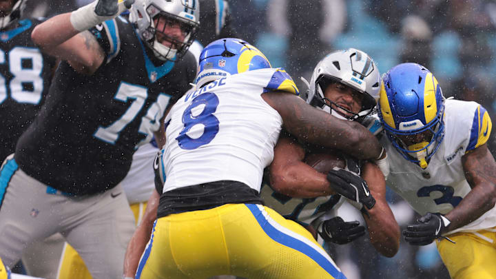 Nov 30, 2025; Charlotte, North Carolina, USA;  Carolina Panthers running back Chuba Hubbard (30) rushes as Los Angeles Rams linebacker Jared Verse (8) defends during the third quarter at Bank of America Stadium. Mandatory Credit: Scott Kinser-Imagn Images