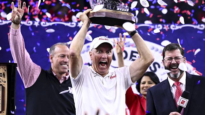 Dec 27, 2025; Houston, TX, USA; Houston Cougars head coach Willie Fritz hoists the champions trophy after the win over Louisiana State Tigers at NRG Stadium. Mandatory Credit: Maria Lysaker-Imagn Images 