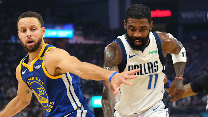 Dec 15, 2024; San Francisco, California, USA; Dallas Mavericks guard Kyrie Irving (11) dribbles against Golden State Warriors guard Stephen Curry (30) and forward Trayce Jackson-Davis (right) during the first quarter at Chase Center. Mandatory Credit: Darren Yamashita-Imagn Images