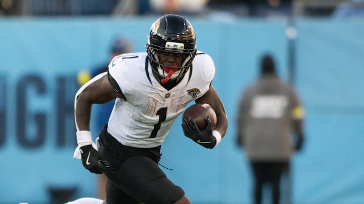 Nov 30, 2025; Nashville, Tennessee, USA;  Jacksonville Jaguars running back Travis Etienne Jr. (1) runs with the ball against the Tennessee Titans during the second half at Nissan Stadium. Mandatory Credit: Steve Roberts-Imagn Images