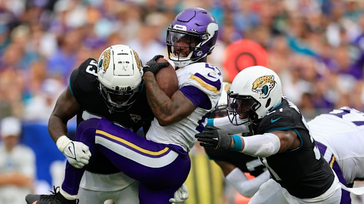 Jacksonville Jaguars linebacker Devin Lloyd (33) and linebacker Ventrell Miller (51) combine to tackle Minnesota Vikings running back Cam Akers (27) during the fourth quarter of an NFL football matchup Sunday, Nov. 10, 2024 at Everbank Stadium in Jacksonville, Fla. The Vikings defeated the Jaguars 12-7. [Corey Perrine/Florida Times-Union]
