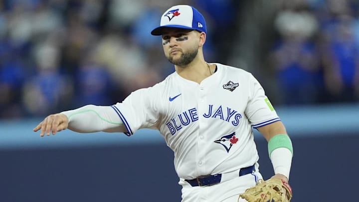 Nov 1, 2025; Toronto, Ontario, CAN; Toronto Blue Jays designated hitter Bo Bichette (11) throws to first for an out against Los Angeles Dodgers second baseman Tommy Edman (25) in the eighth inning during game seven of the 2025 MLB World Series at Rogers Centre. Mandatory Credit: John E. Sokolowski-Imagn Images
