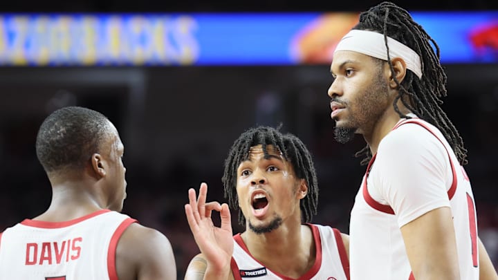 Arkansas Razorbacks guard D.J. Wagner (middle) sets the plan with guard Johnell Davis (left) and center Jonas Aidoo during the Hogs' 93-92 win against the Mississippi State Bulldogs at Bud Walton Arena on Saturday.