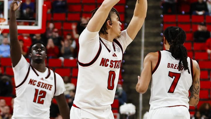 Dec 6, 2025; Raleigh, North Carolina, USA; NC State Wolfpack guard Jordan Snell (0) celebrates a 3-point shot during the second half of the game against the Liberty Flames at Lenovo Center. Mandatory Credit: Jaylynn Nash-Imagn Images