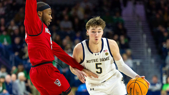 Feb 28, 2026; South Bend, Indiana, USA; Notre Dame Fighting Irish guard Cole Certa (5) drives against NC State Wolfpack guard Tre Holloman (5) during the first half at Purcell Pavilion at the Joyce Center. Mandatory Credit: Michael Caterina-Imagn Images