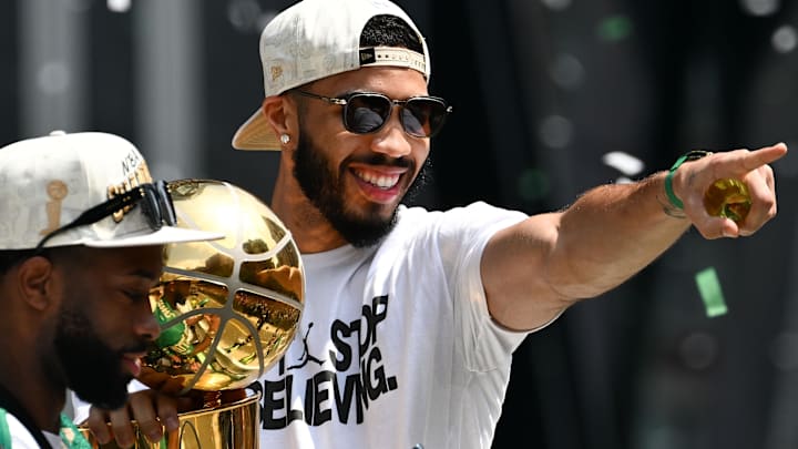 Jun 21, 2024; Boston, MA, USA; Boston Celtics forward Jayson Tatum (0) points to the crowd with the Larry O'Brien Championship Trophy during the 2024 NBA Championship parade in Boston. Mandatory Credit: Brian Fluharty-Imagn Images