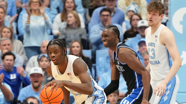 Feb 7, 2026; Chapel Hill, North Carolina, USA;  North Carolina Tar Heels forward Caleb Wilson (8) with the ball as Duke Blue Devils guard Dame Sarr (7) defends and center Henri Veesaar (13) is in the background in the second half at Dean E. Smith Center. Mandatory Credit: Bob Donnan-Imagn Images