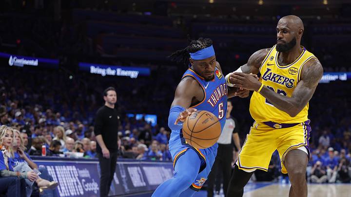 Thunder guard Luguentz Dort drives around Lakers forward LeBron James.