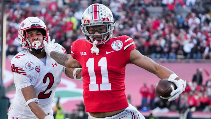 Ohio State wide receiver Jaxon Smith-Njigba fends off Utah cornerback Micah Bernard as he races to the end zone for a touchdown during the second quarter of the 2022 Rose Bowl in Pasadena, Calif.