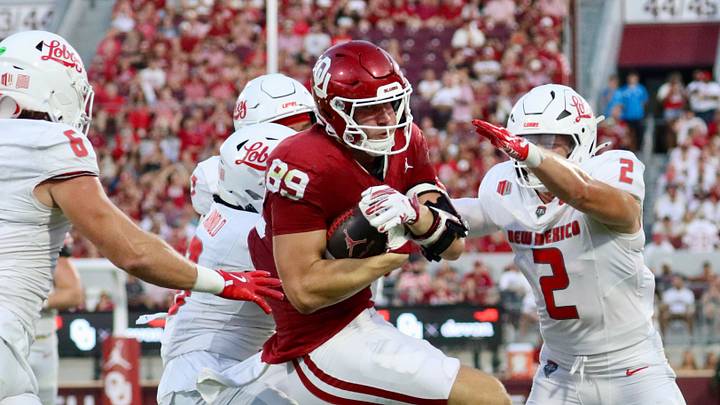 Oklahoma tight end Hayden Hansen carries New Mexico defenders into the end zone. Oklahoma tight end Hayden Hansen carries New Mexico defenders into the end zone.