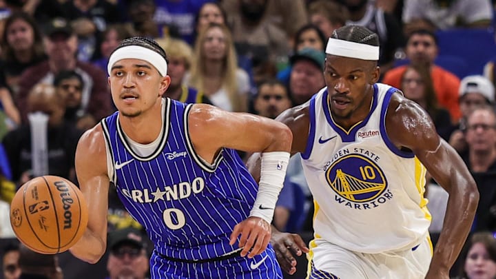 Nov 18, 2025; Orlando, Florida, USA; Orlando Magic guard Anthony Black (0) brings the ball up court in front of Golden State Warriors forward Jimmy Butler III (10) during the second quarter at Kia Center. Mandatory Credit: Mike Watters-Imagn Images
