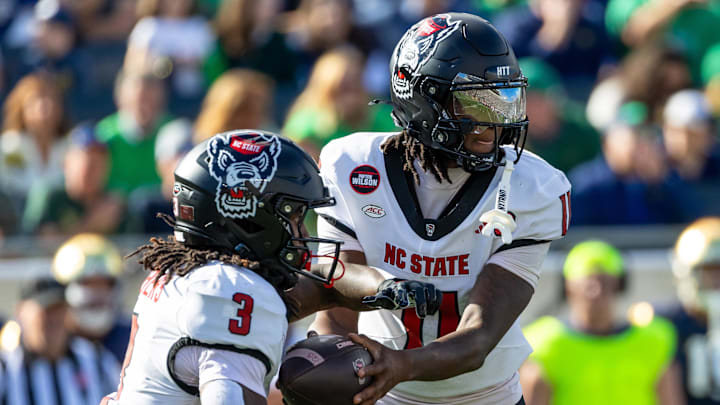 Oct 11, 2025; South Bend, Indiana, USA; NC State Wolfpack quarterback CJ Bailey (11) hands off to running back Hollywood Smothers (3) during the first half at Notre Dame Stadium. Mandatory Credit: Michael Caterina-Imagn Images