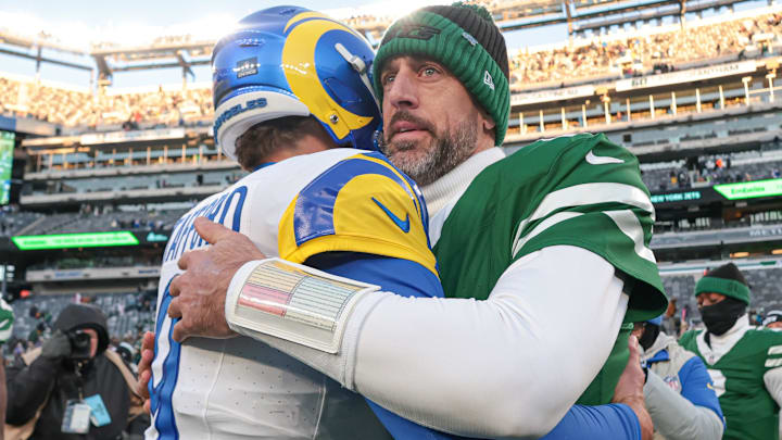 Dec 22, 2024; East Rutherford, New Jersey, USA;  Los Angeles Rams quarterback Matthew Stafford (9) hits New York Jets quarterback Aaron Rodgers (8) after the game at MetLife Stadium. Mandatory Credit: Vincent Carchietta-Imagn Images