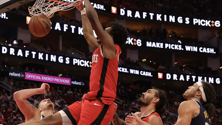 Apr 13, 2025; Houston, Texas, USA;  Houston Rockets forward Amen Thompson (1) dunks against Denver Nuggets center Nikola Jokic (15) in the second quarter  at Toyota Center. Mandatory Credit: Thomas Shea-Imagn Images