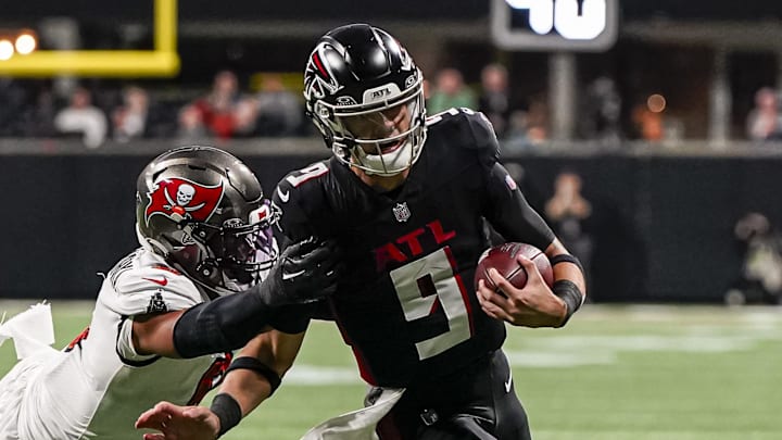 Dec 10, 2023; Atlanta, Georgia, USA; Atlanta Falcons quarterback Desmond Ridder (9) breaks a tackle by Tampa Bay Buccaneers linebacker SirVocea Dennis (8) to score a touchdown during the second half at Mercedes-Benz Stadium. Mandatory Credit: Dale Zanine-Imagn Images