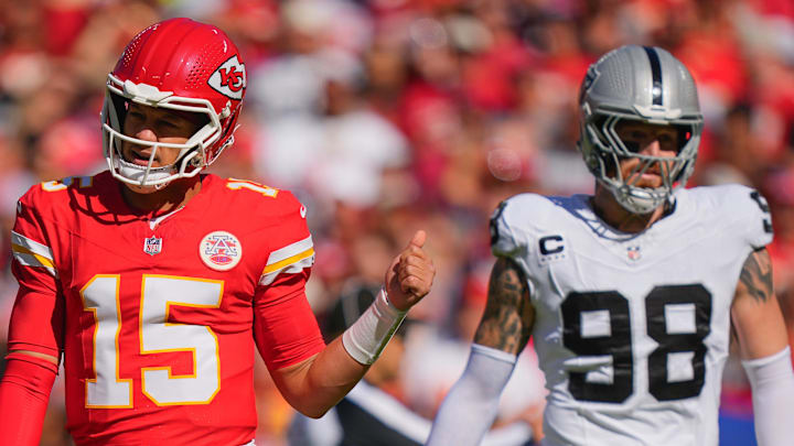 Oct 19, 2025; Kansas City, Missouri, USA; Kansas City Chiefs quarterback Patrick Mahomes (15) gestures as Las Vegas Raiders defensive end Maxx Crosby (98) looks on during the first quarter of the game at GEHA Field at Arrowhead Stadium. Mandatory Credit: Jay Biggerstaff-Imagn Images