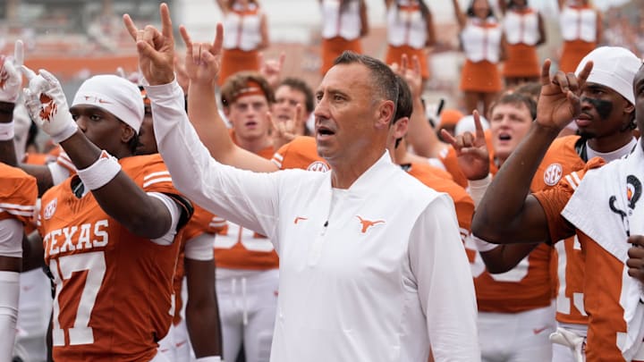Texas Longhorns head coach Steve Sarkisian and players hold up their horns with the fans during the singing of the Eyes of Texas after a victory over the San Jose State Spartans at Darrell K Royal-Texas Memorial Stadium. 