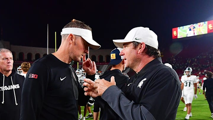 Sep 20, 2025; Los Angeles, California, USA; Southern California Trojans head coach Lincoln Riley meets with Michigan State Spartans head coach Jonathan Smith following the game at the Los Angeles Memorial Coliseum. Mandatory Credit: Gary A. Vasquez-Imagn Images