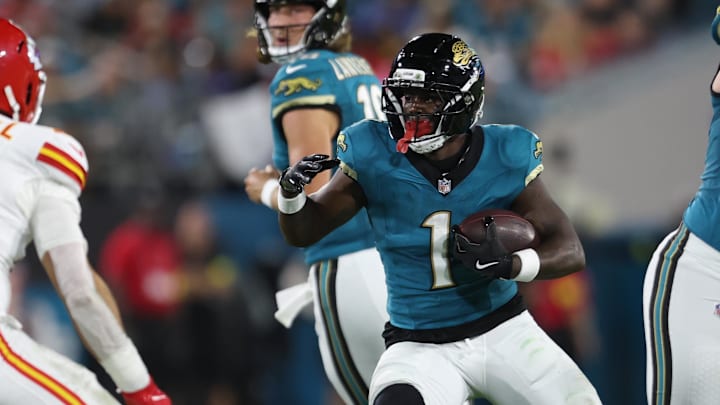 Oct 6, 2025; Jacksonville, Florida, USA; Jacksonville Jaguars running back Travis Etienne (1) runs against Kansas City Chiefs linebacker Drue Tranquill (23) during the first quarter at EverBank Stadium. Mandatory Credit: Morgan Tencza-Imagn Images