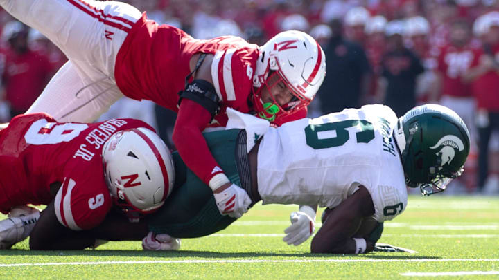 Oct 4, 2025; Lincoln, Nebraska, USA; Nebraska Cornhuskers linebacker Vincent Shavers Jr. (9) and defensive back DeShon Singleton (8) tackle Michigan State Spartans wide receiver Nick Marsh (6) at Memorial Stadium.