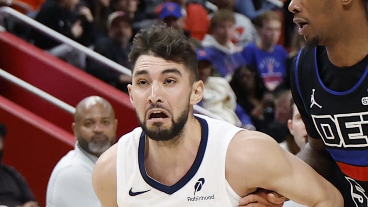 Memphis Grizzlies guard Ty Jerome dribbles defended by Detroit Pistons forward Ronald Holland II.