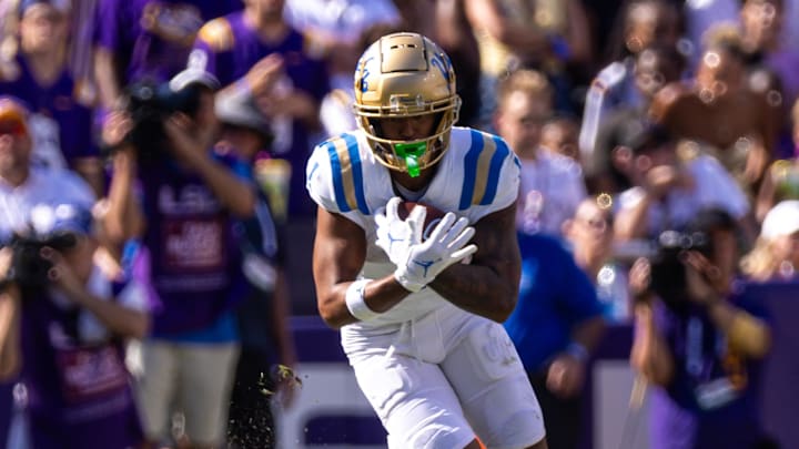Sep 21, 2024; Baton Rouge, Louisiana, USA;  UCLA Bruins wide receiver Rico Flores Jr. (1) runs with the ball against LSU Tigers cornerback Ashton Stamps (1) during the first half at Tiger Stadium. Mandatory Credit: Stephen Lew-Imagn Images