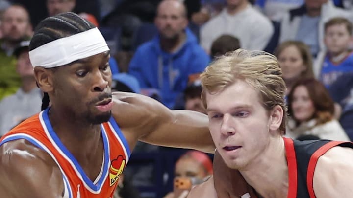 Toronto Raptors guard/forward Gradey Dick moves the ball past Oklahoma City Thunder guard Shai Gilgeous-Alexander.