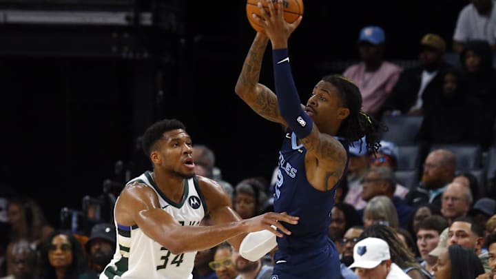 Oct 31, 2024; Memphis, Tennessee, USA; Memphis Grizzlies guard Ja Morant (12) passes the ball as Milwaukee Bucks forward Giannis Antetokounmpo (34) defends during the first half at FedExForum. Mandatory Credit: Petre Thomas-Imagn Images