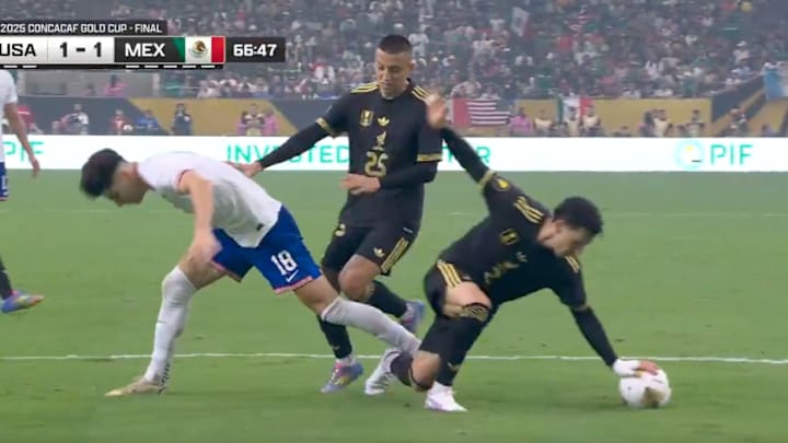 Mexico defender Jorge Sanchez falls with his hand on the ball in the box against USA in the Gold Cup Final. Mexico defender Jorge Sanchez falls with his hand on the ball in the box against USA in the Gold Cup Final.