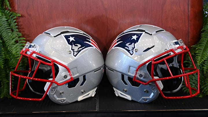 A pair of New England Patriots helmets sit in front of the podium before a press conference at Gillette Stadium.