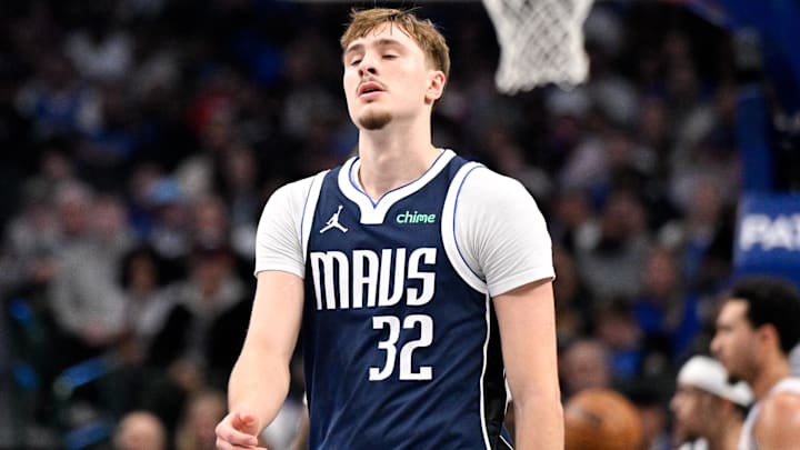 Jan 1, 2026; Dallas, Texas, USA; Dallas Mavericks forward Cooper Flagg (32) reacts to a dunk by Philadelphia 76ers forward Paul George (8) during the second quarter at the American Airlines Center. Mandatory Credit: Jerome Miron-Imagn Images