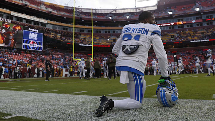 Nov 9, 2025; Landover, Maryland, USA; Detroit Lions cornerback Amik Robertson (21) kneels on the field during warmups prior to a game against the Washington Commanders at Northwest Stadium. Mandatory Credit: Peter Casey-Imagn Images