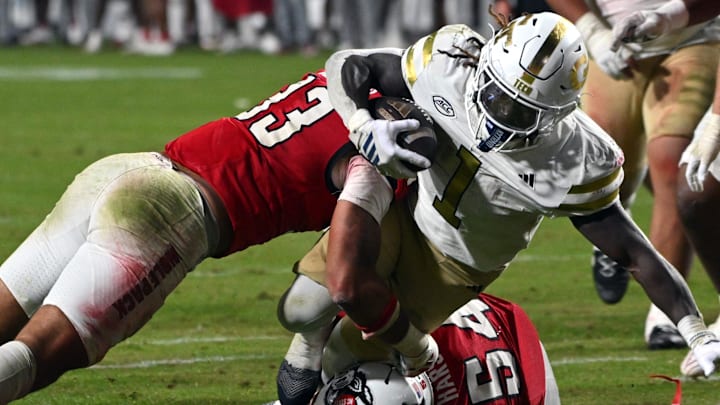 Nov 1, 2025; Raleigh, North Carolina, USA;  North Carolina State Wolfpack linebacker Kenny Soares Jr. (33) tackles Georgia Tech Yellow Jackets running back Jamal Haynes (1) during the fourth quarter at Carter-Finley Stadium. Mandatory Credit: Zachary Taft-Imagn Images