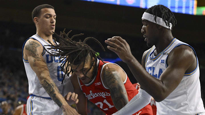 Feb 23, 2025; Los Angeles, California, USA; UCLA Bruins guard Kobe Johnson (0), Ohio State Buckeyes forward Devin Royal (21) and UCLA Bruins guard Eric Dailey Jr. (3) battle for the ball under the basket during the first quarter at Pauley Pavilion presented by Wescom. Mandatory Credit: Robert Hanashiro-Imagn Images