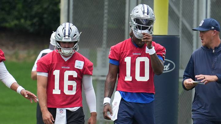 Dallas Cowboys quarterback Sam Howell and Joe Milton III walk onto the field during practice at The Star