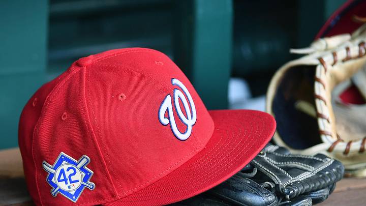 Red Washington Nationals hat on top of a black mitt