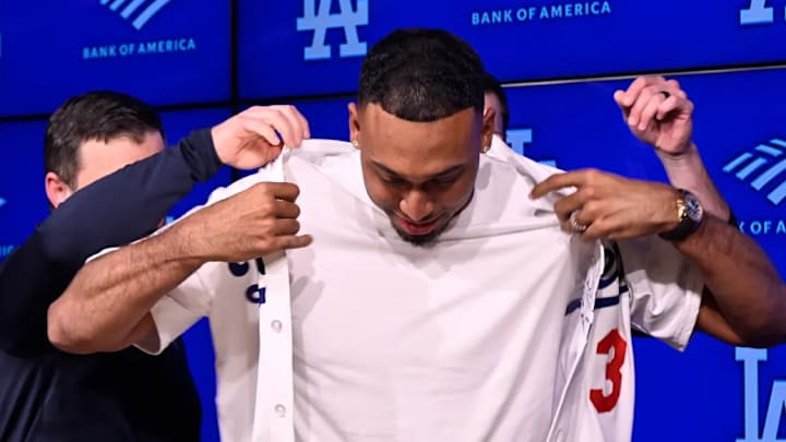 Los Angeles, CA - December 12: Former New York Mets closer Edwin Diaz, center, tries on the LosAngeles Dodgers jersey with help from Andrew Friedman, left, President of baseball operations and Brandon Gomes, General manager at Dodger Stadium in Los Angeles on Friday, December 12, 2025.
