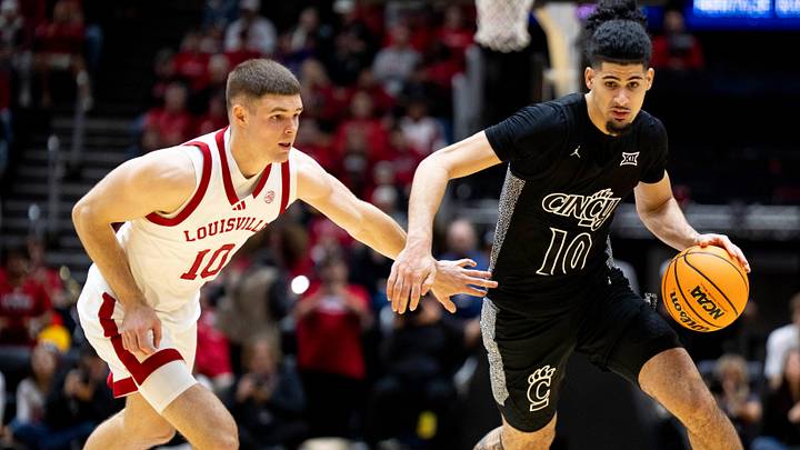 Cincinnati Bearcats guard Shon Abaev (10) drives on Louisville Cardinals guard Isaac McKneely (10) in the second half of the NCAA Basketball game at Heritage Bank Center in Cincinnati on Nov. 21, 2025.