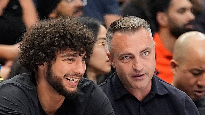 Jun 27, 2026; Toronto, Ontario, CAN;  Toronto Raptors 2026 first round draft pick Allen Graves (center) sits courtside with head coach Darko Rajakovic (right) during a game between the Phoenix Mercury and Toronto Tempo at Scotiabank Arena. Mandatory Credit: John E. Sokolowski-Imagn Images