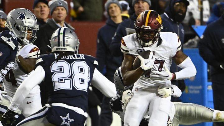 Jan 7, 2024; Landover, Maryland, USA; Washington Commanders wide receiver Terry McLaurin (17) runs after a catch as Dallas Cowboys safety Malik Hooker (28) defends during the first half at FedExField. Mandatory Credit: Brad Mills-USA TODAY Sports
