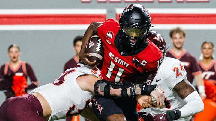 Sep 27, 2025; Raleigh, North Carolina, USA; North Carolina State Wolfpack quarterback CJ Bailey (11) attempts to run the ball but tackled by Virginia Tech Hokies defensive lineman Ben Bell (33) and linebacker Jaden Keller (24) during the first half of the game at Carter-Finley Stadium. Mandatory Credit: Jaylynn Nash-Imagn Images Sep 27, 2025; Raleigh, North Carolina, USA; North Carolina State Wolfpack quarterback CJ Bailey (11) attempts to run the ball but tackled by Virginia Tech Hokies defensive lineman Ben Bell (33) and linebacker Jaden Keller (24) during the first half of the game at Carter-Finley Stadium. Mandatory Credit: Jaylynn Nash-Imagn Images