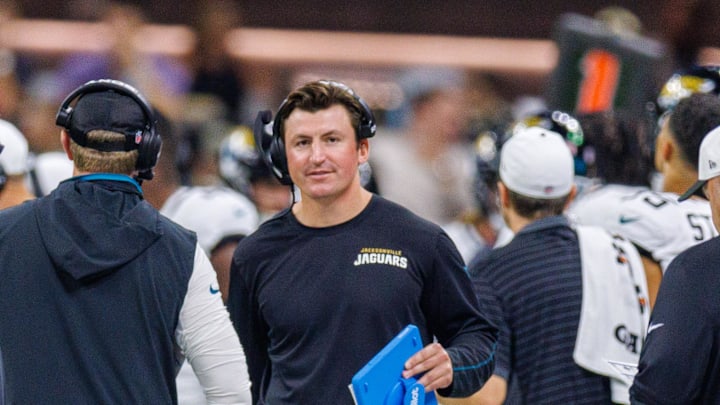 Aug 17, 2025; New Orleans, Louisiana, USA;  Jacksonville Jaguars offensive coordinator Grant Udinski  (blue binder) reacts to a touchdown against the New Orleans Saints during the first half at Caesars Superdome. Mandatory Credit: Stephen Lew-Imagn Images
