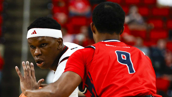 Dec 6, 2025; Raleigh, North Carolina, USA; NC State Wolfpack forward Ven-Allen Lubin (22) holds the ball guarded by Liberty Flames guard JJ Harper (9) during the first half of the game at Lenovo Center. Mandatory Credit: Jaylynn Nash-Imagn Images