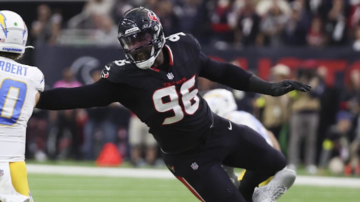 Jan 11, 2025; Houston, Texas, USA;  Los Angeles Chargers quarterback Justin Herbert (10) is defended by Houston Texans defensive end Denico Autry (96) in the second quarter in an AFC wild card game at NRG Stadium. Mandatory Credit: Thomas Shea-Imagn Images