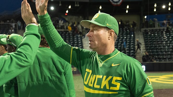 Oregon baseball coach Mark Wasikowski, right, congratulates the team after their season-opening win over George Mason at PK Park in Eugene, Feb. 13, 2026.