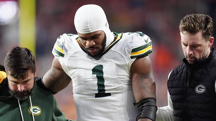 Green Bay Packers defensive end Micah Parsons walks off the field with help from medical personnel following his knee injury.
