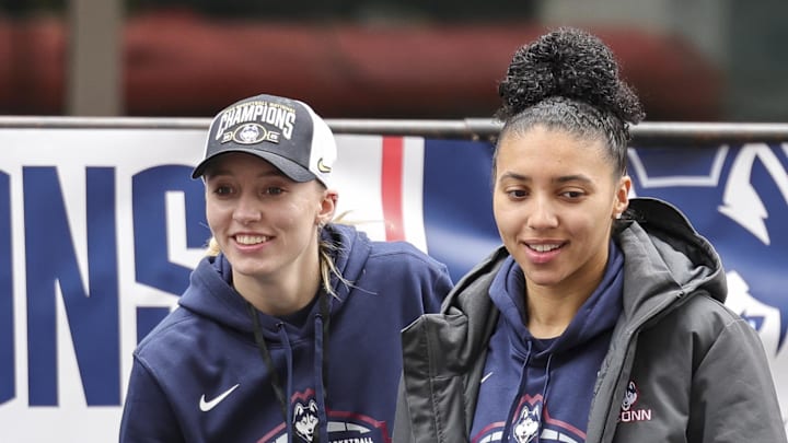 Apr 13, 2025; Hartford, CT, USA;  UConn student-athlete Paige Bueckers and UConn student-athlete Azzi Fudd walk onto the stage during the Final Four Champions victory parade and rally outside of the XL Center in Hartford, CT. Mandatory Credit: Scott Rausenberger-Imagn Images